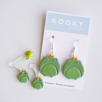 Green frog-shaped earrings on a Kooky Boutique NZ card against a white background